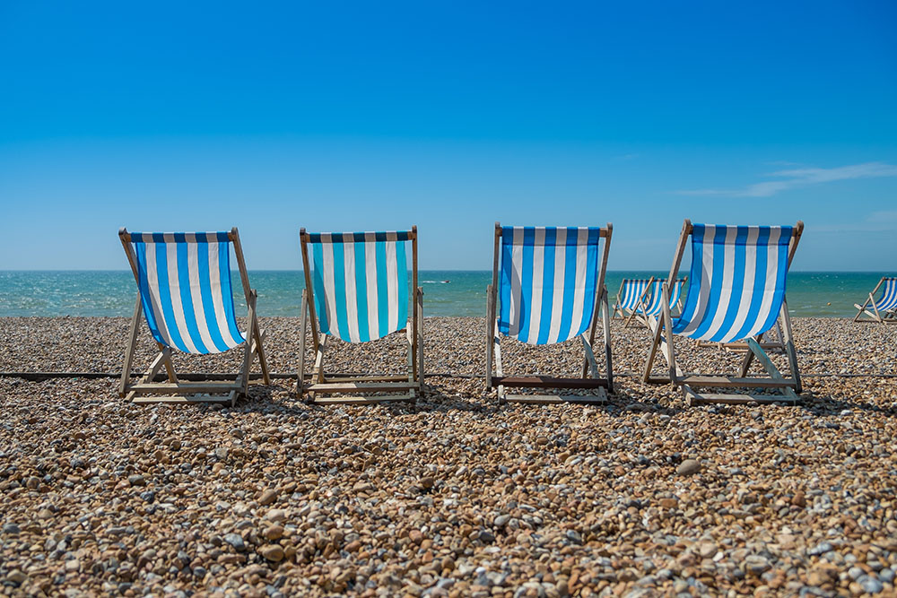 4 deck chairs on a pebble beach